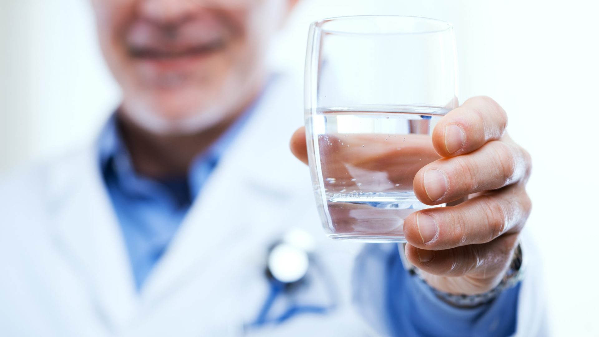 Doctor offering a glass of water, healthy lifestyle concept.